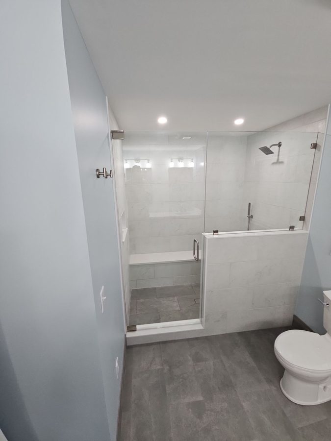 Bedford — accessible glass-enclosed shower with bench seat and half-wall