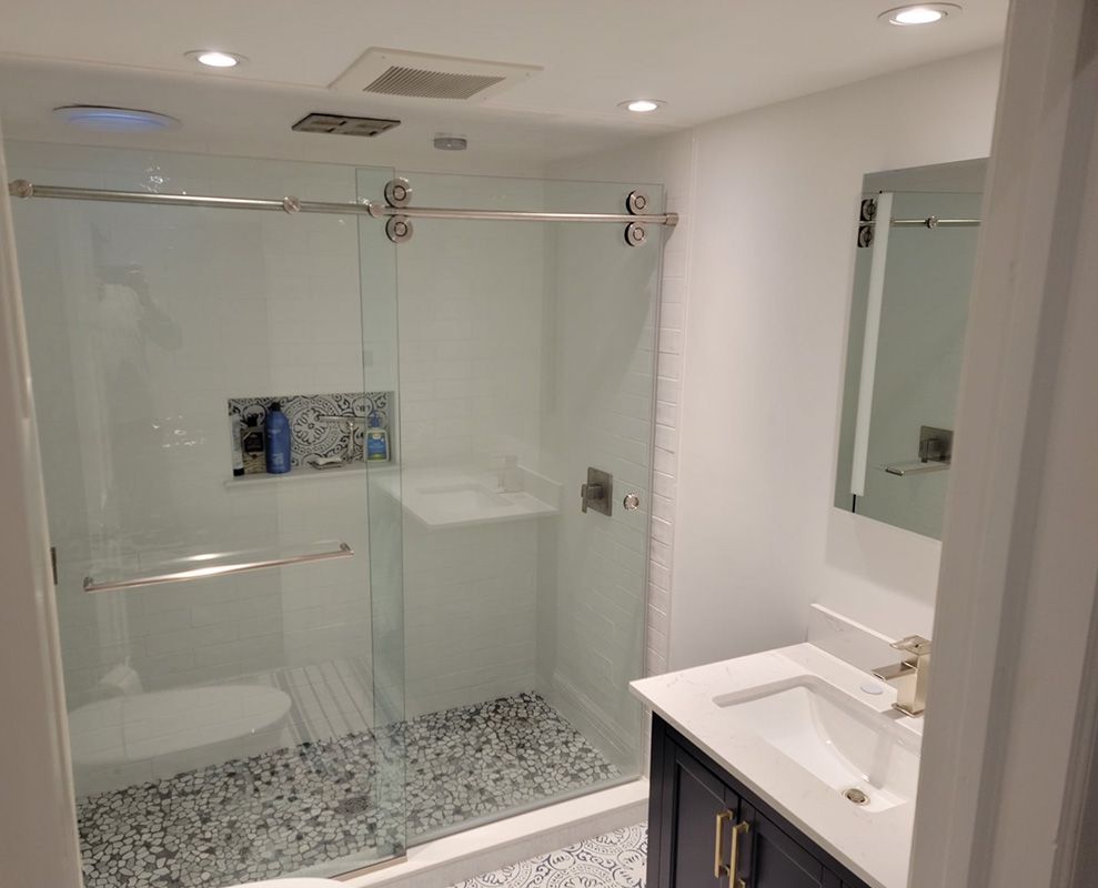 Folly Mills — bathroom remodel with frameless sliding glass shower door and pebble floor