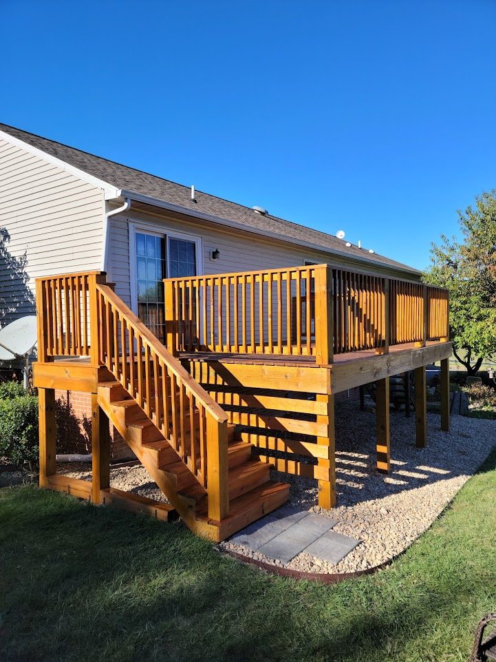 Bell Vista — cedar-stained custom deck with railing and stair access over stone landing