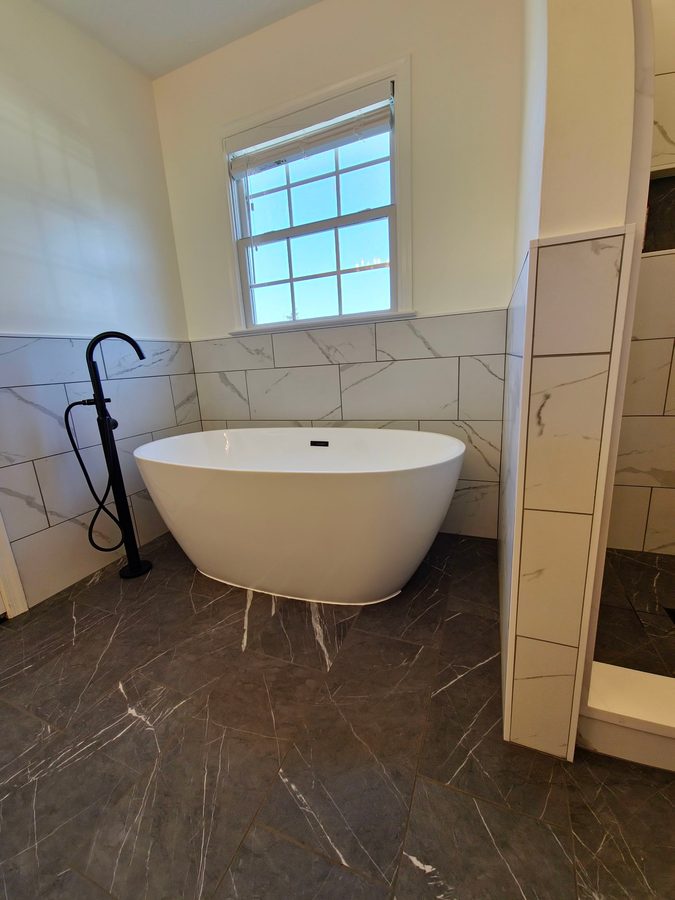 Freestanding soaker tub with marble tile