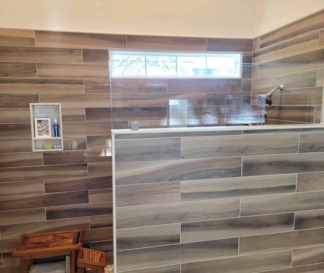 Forest — walk-in shower with tiled knee wall, built-in niche, and clerestory window