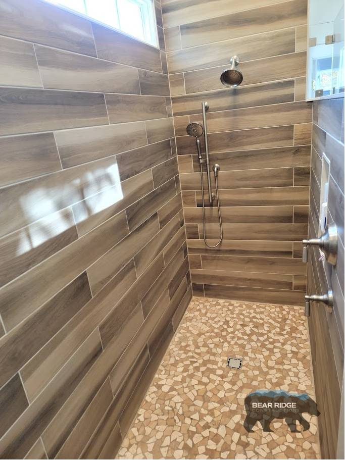 Forest — walk-in shower with wood-look plank tile and pebble mosaic floor
