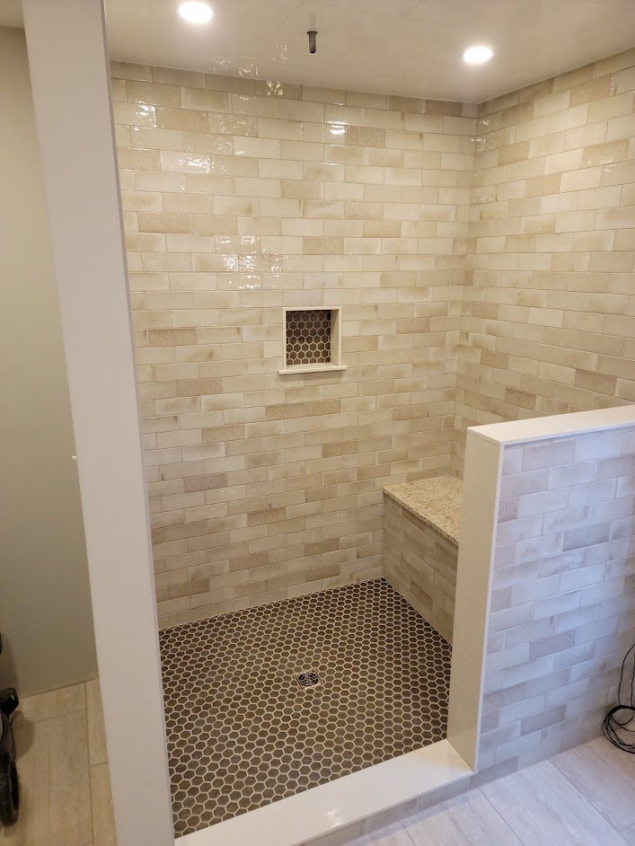 Saddle Ridge — walk-in shower with built-in tiled bench and hexagon mosaic floor